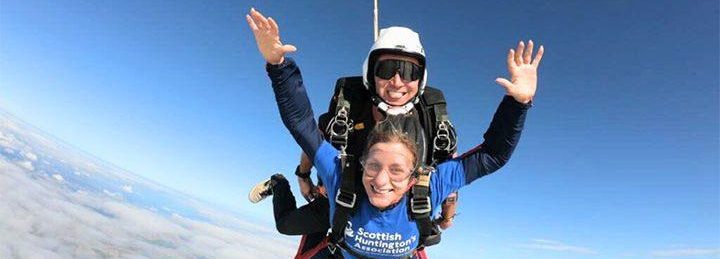 Two people smiling and skydiving