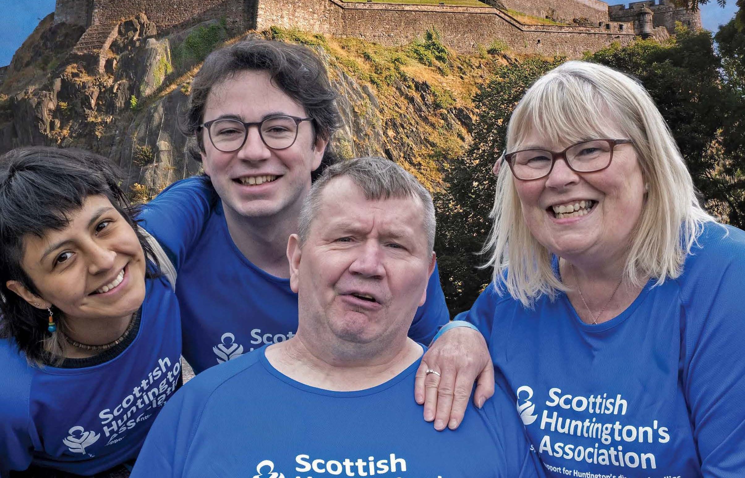 Family wearing Scottish Huntington's Association t-shirts with Edinburgh Castle in the background